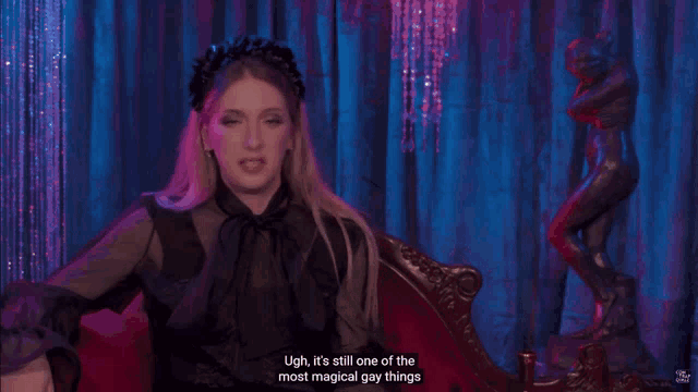 a woman sitting in front of a statue with the words " ugh it 's still one of the most magical gay things "