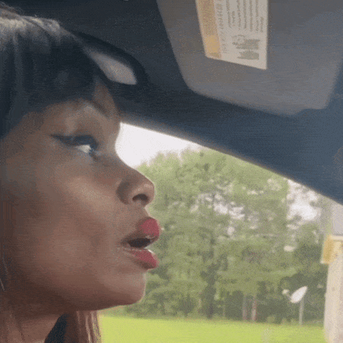 a woman in a car with a sun visor that says " warning " on it