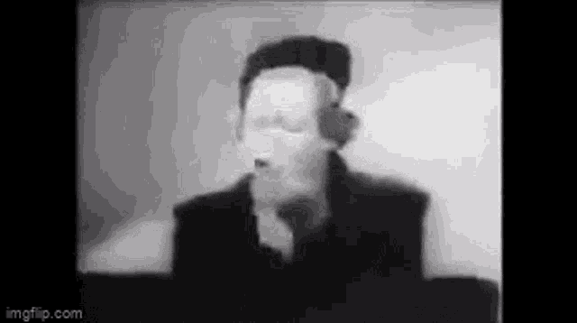 a black and white photo of a man wearing headphones and a mask .