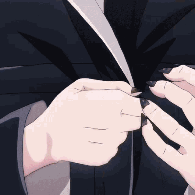 a close up of a person 's hands with black nails holding something