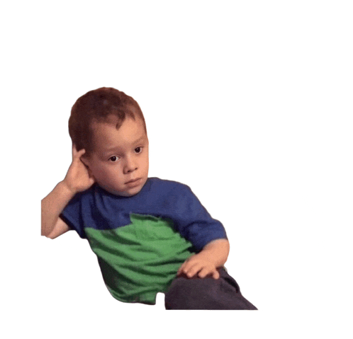 a young boy in a blue and green shirt is sitting on the floor with his hand behind his ear