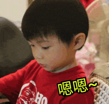 a young boy wearing a red shirt with chinese writing on it