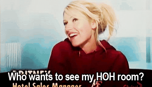 a woman in a red hoodie is smiling with the words who wants to see my hoh room below her