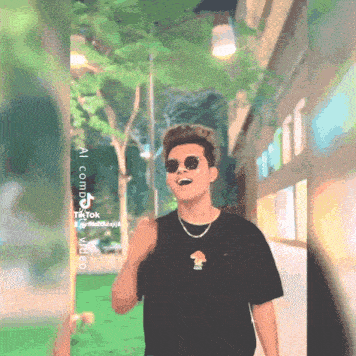 a man wearing sunglasses and a black t-shirt with a mushroom on the front