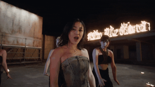 a group of women are dancing in front of a sign that says ' twice '