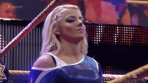a woman is standing in a wrestling ring and looking up .