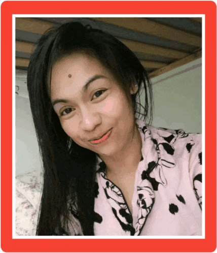 a woman with a spot on her forehead smiles for a picture