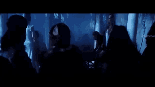 a group of people standing in a dark room with the words coucou coucou written on the bottom