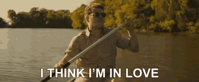 a man in a boat with the words i think i 'm in love below him