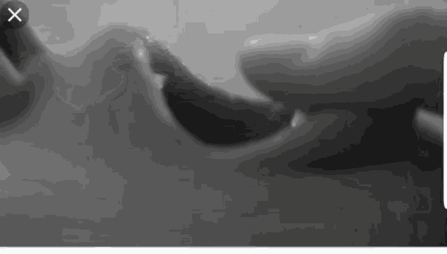 a black and white photo of a person 's hands with an x on the bottom right