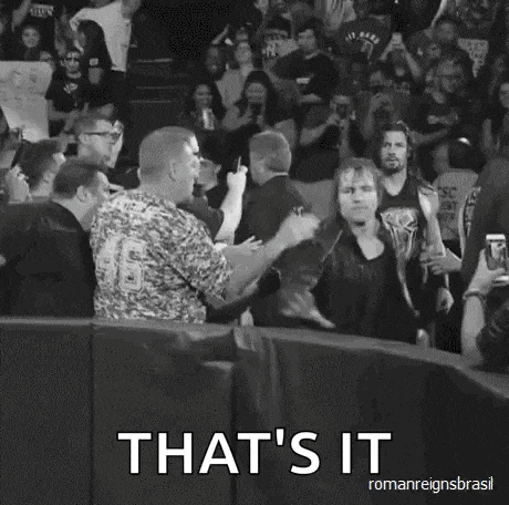 a man in a tank top is holding a sign in front of a crowd and says `` that 's it ''