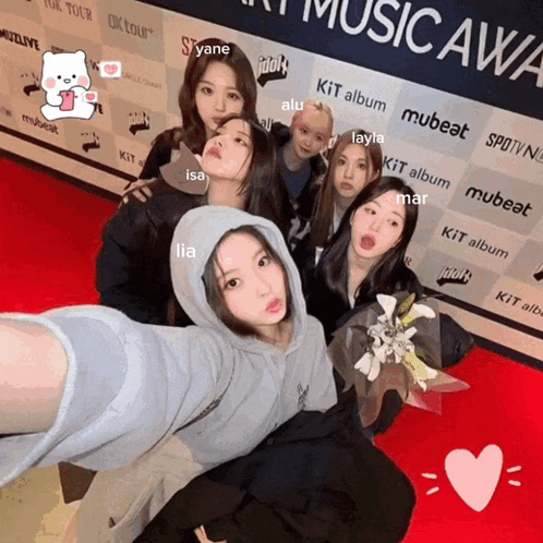 a group of girls posing on a red carpet in front of a wall that says music award