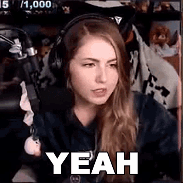 a woman wearing headphones is sitting in front of a microphone .