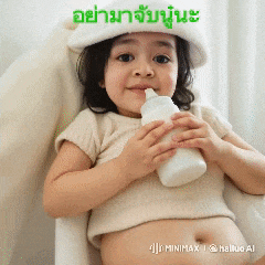 a little girl wearing a white hat is holding a bottle