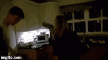 two women are dancing together in a dark room .