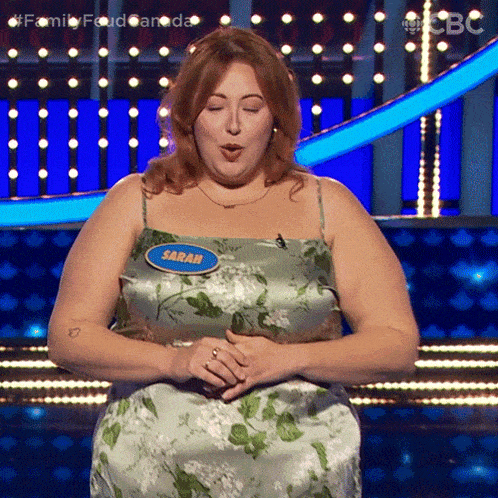 a woman in a floral dress has a name tag that says sarah on it