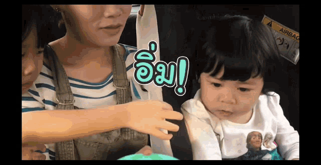 a woman holds a baby in a car seat with a sign that says airbag on it
