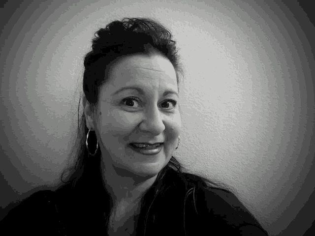 a black and white photo of a smiling woman