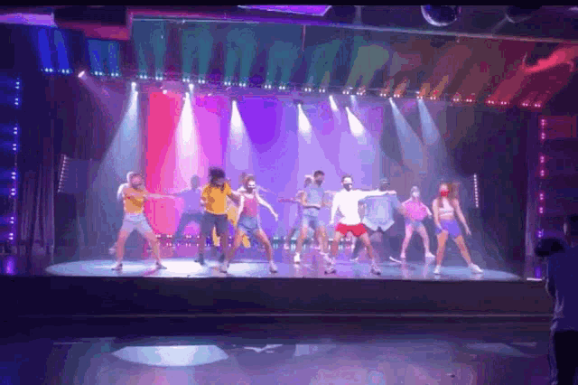 a group of young people are dancing on a stage