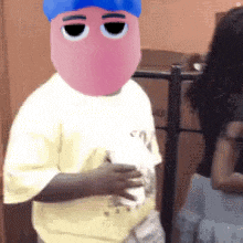 a person with a pink face and a blue hat on