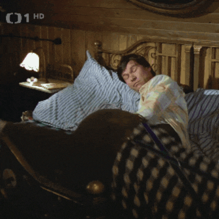 a man is sleeping in a bed with the number 01 hd on the bottom right