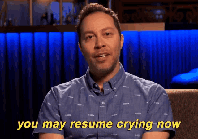 a man in a blue shirt says " you may resume crying now " in yellow letters