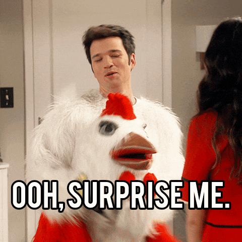 a man dressed in a chicken costume says ooh surprise me