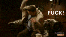 a man in a suit and tie is sitting on a couch with the words fuck written on the bottom