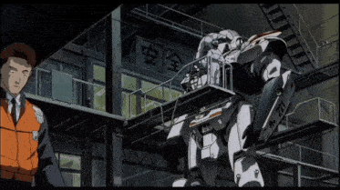 a man in an orange vest stands next to a robot with a license plate that says " rh-071 "