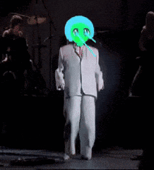 a man in a white suit with a green face on his head