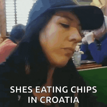 a woman is wearing a hat and eating chips in croatia .