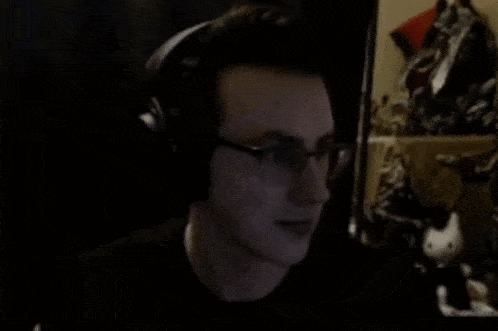 a man wearing glasses and headphones is looking at the camera .