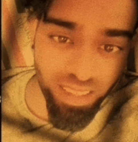 a close up of a man 's face with a beard wearing a sweater