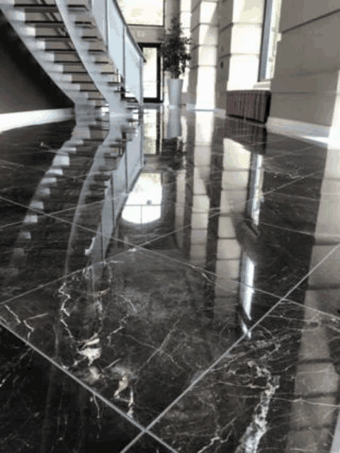 a hallway with a staircase and a marble floor .
