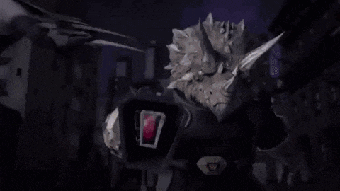 a robot and a dinosaur are fighting each other in the dark .