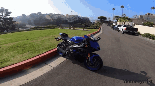 a blue motorcycle is parked on the side of a road with the words motorcyclist on the bottom