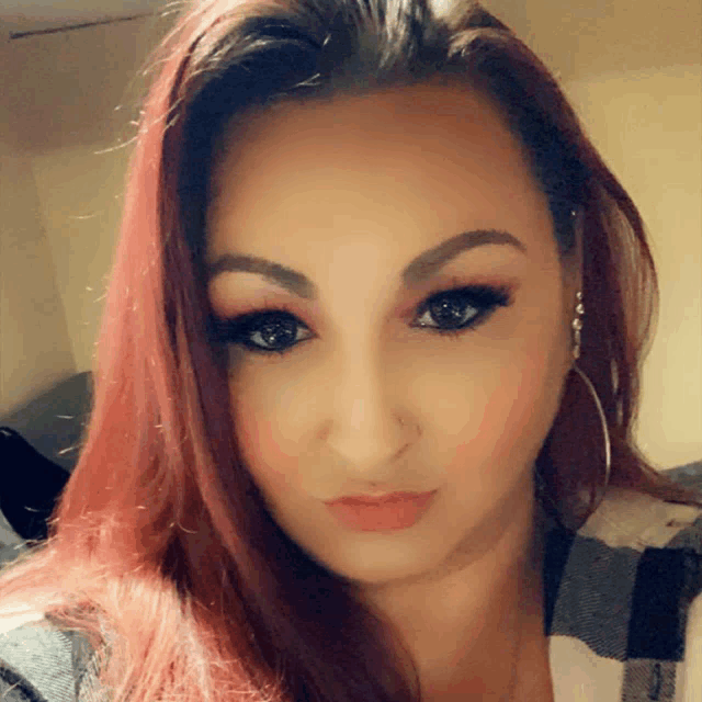 a close up of a woman 's face with red hair