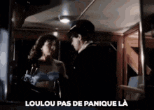 a man and a woman are standing next to each other on a train and the words loulou pas de panique la are above them