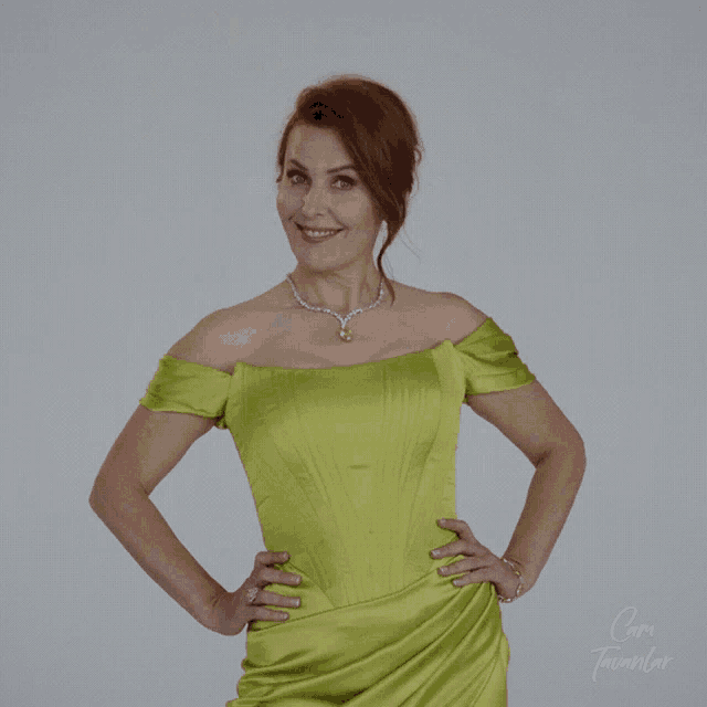 a woman in a green dress is standing with her mouth open