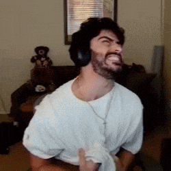a man with a beard is wearing headphones and making a face