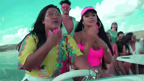 a group of people are sitting on a boat with one woman blowing a kiss .
