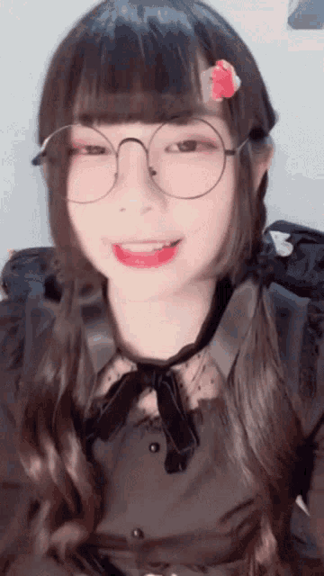 a girl wearing glasses and a flower in her hair is smiling