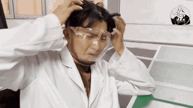 a man in a lab coat is wearing clear safety goggles