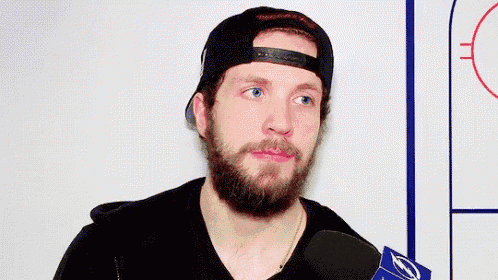 a man with a beard wearing a hat and a necklace that says no .