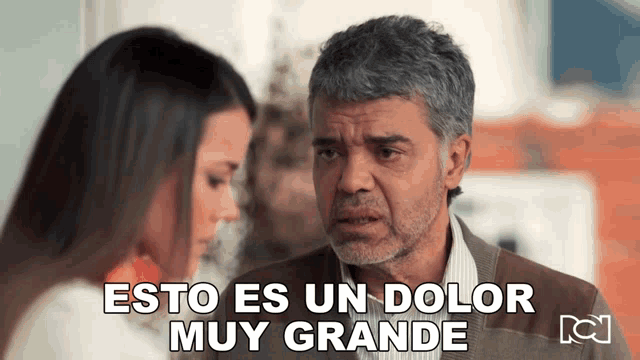 a man and a woman are standing next to each other with the words esto es un dolor muy grande written above them