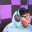 a close up of a person wearing headphones and glasses .