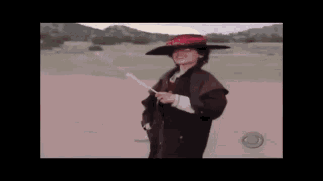 a young boy in a cowboy hat is holding a marshmallow stick .