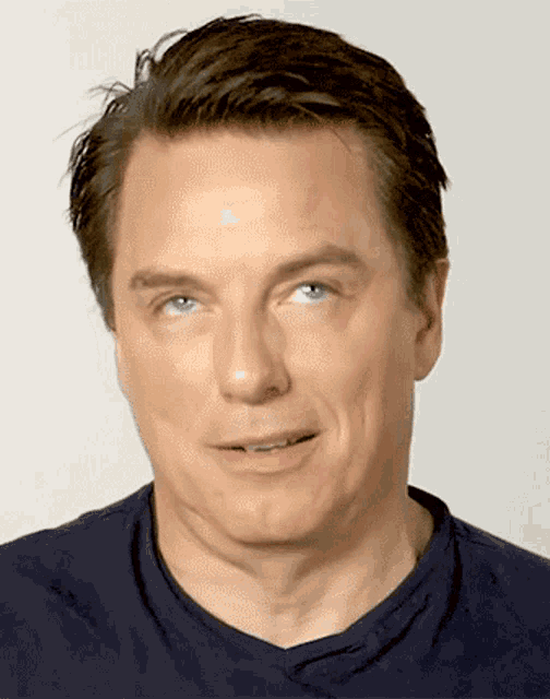 a man wearing a blue shirt looks at the camera