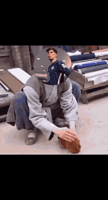 a man kneeling down with a picture of a man in a chelsea jersey