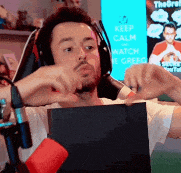 a man wearing headphones is sitting in front of a sign that says " keep calm and watch the grefg "